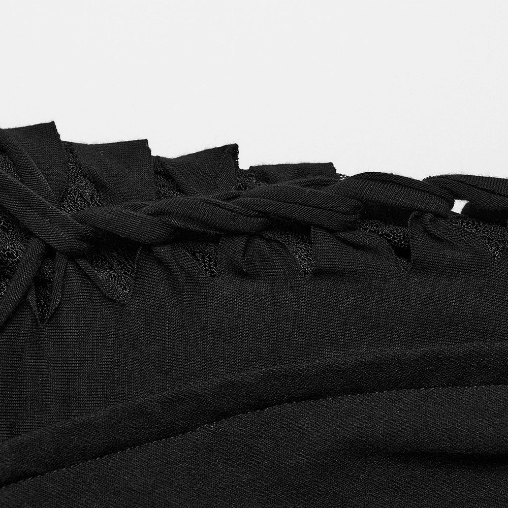 Close-up of black punk asymmetric pants featuring unique mesh detailing and braided design.