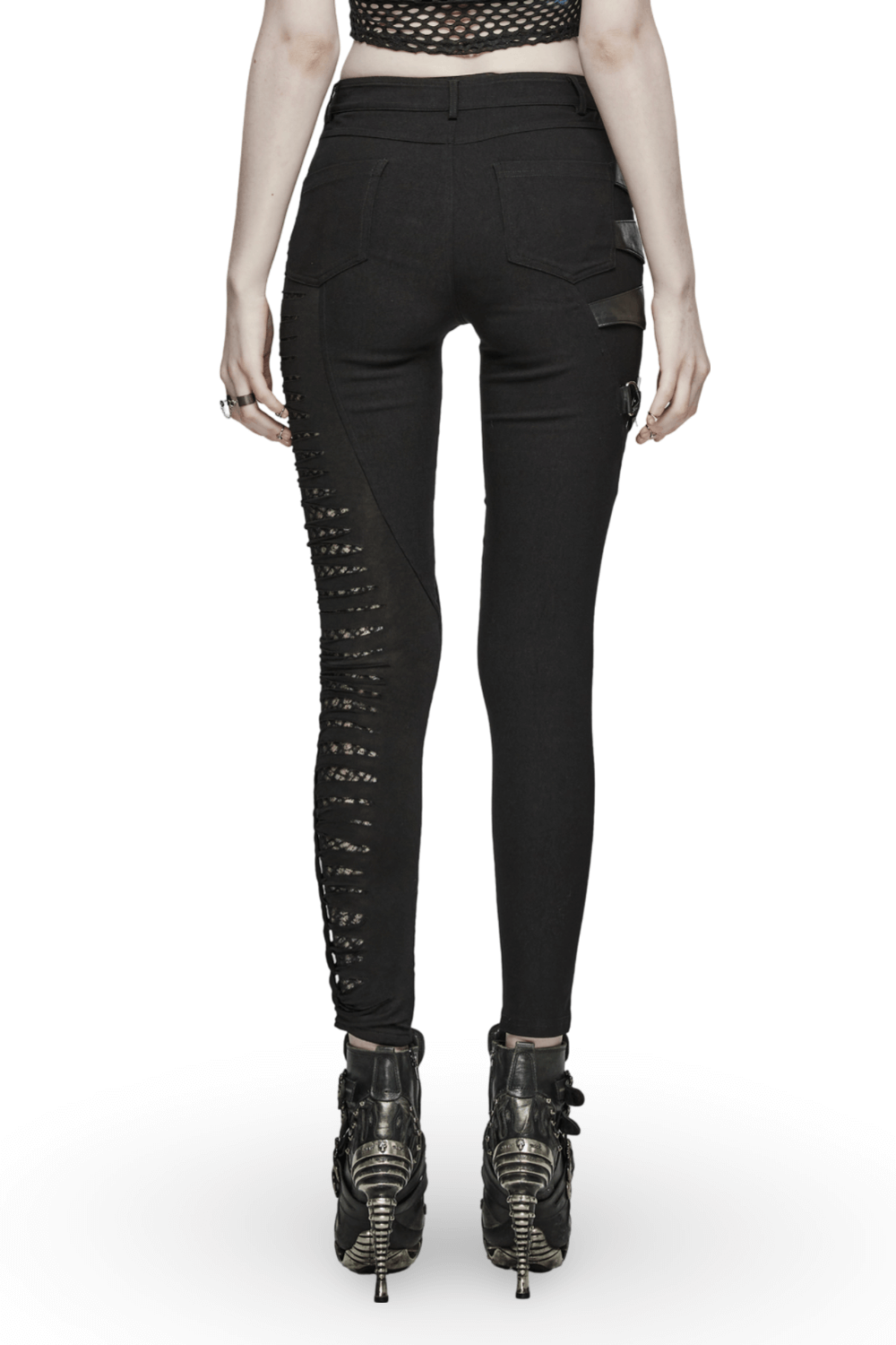 Back view of black punk asymmetric pants with mesh detailing and edgy cutouts, styled with bold heeled boots.
