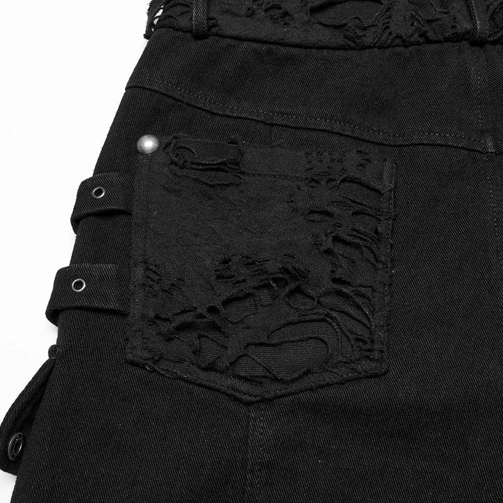 Close-up of black punk denim shorts with tattered pocket detail and edgy embellishments, perfect for alternative fashion.