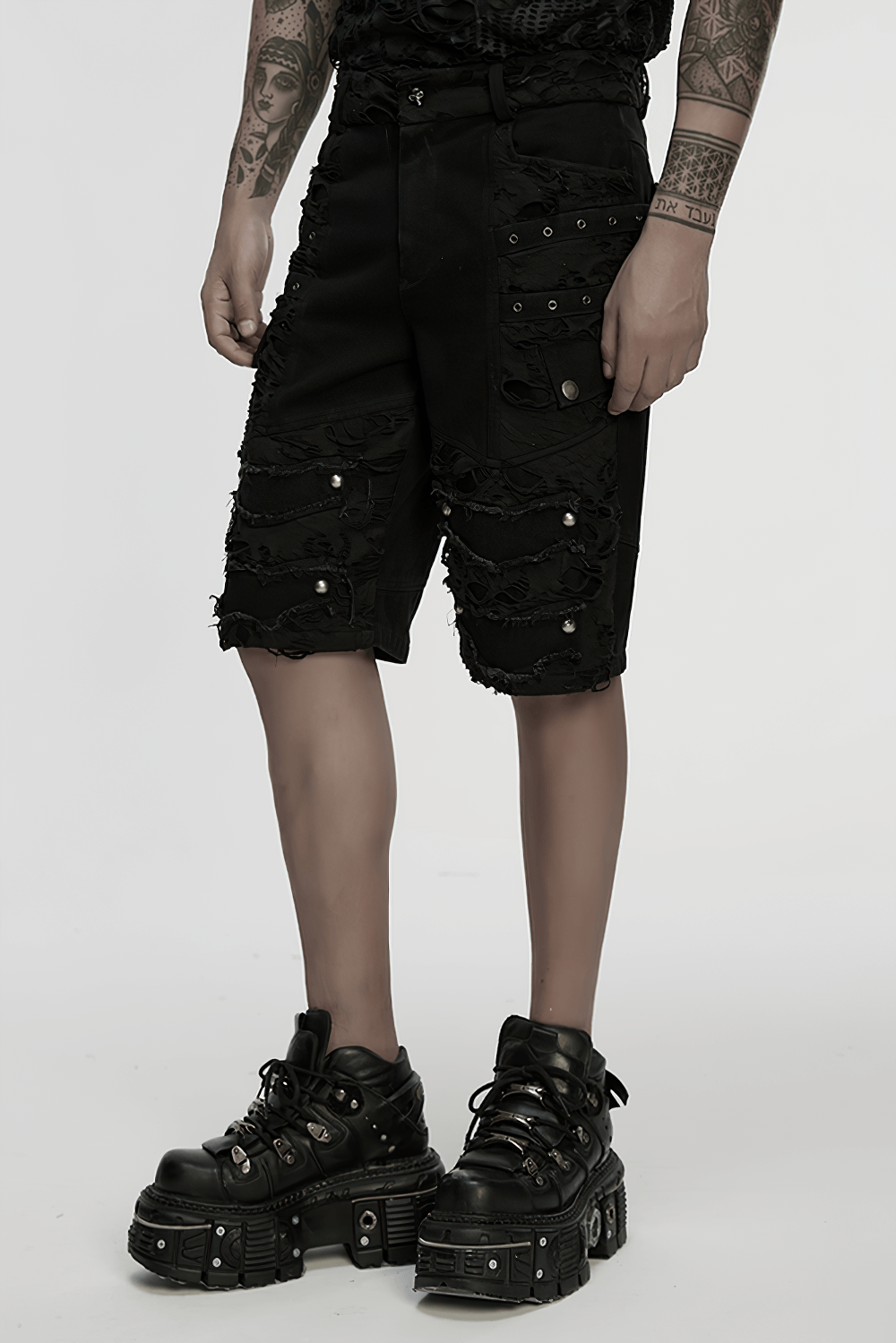 Black punk denim shorts with tattered details and tassels, styled for a bold alternative fashion look.
