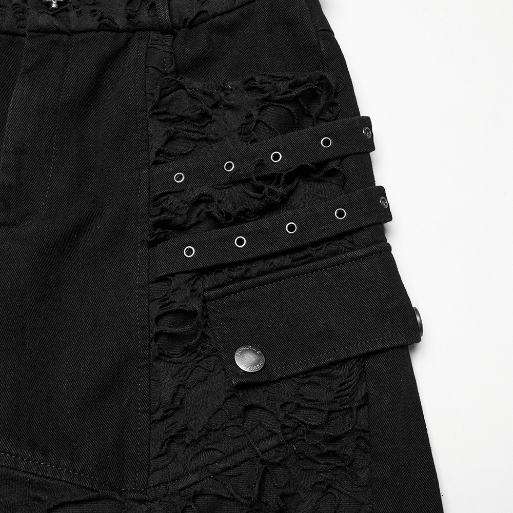 Close-up of black punk denim shorts featuring tattered detail, frayed fabric, and stylish tassel accents.