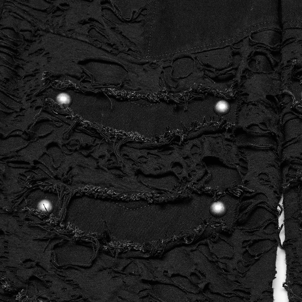 Close-up of black punk denim shorts showing tattered details and decorative buttons for a bold fashion statement.