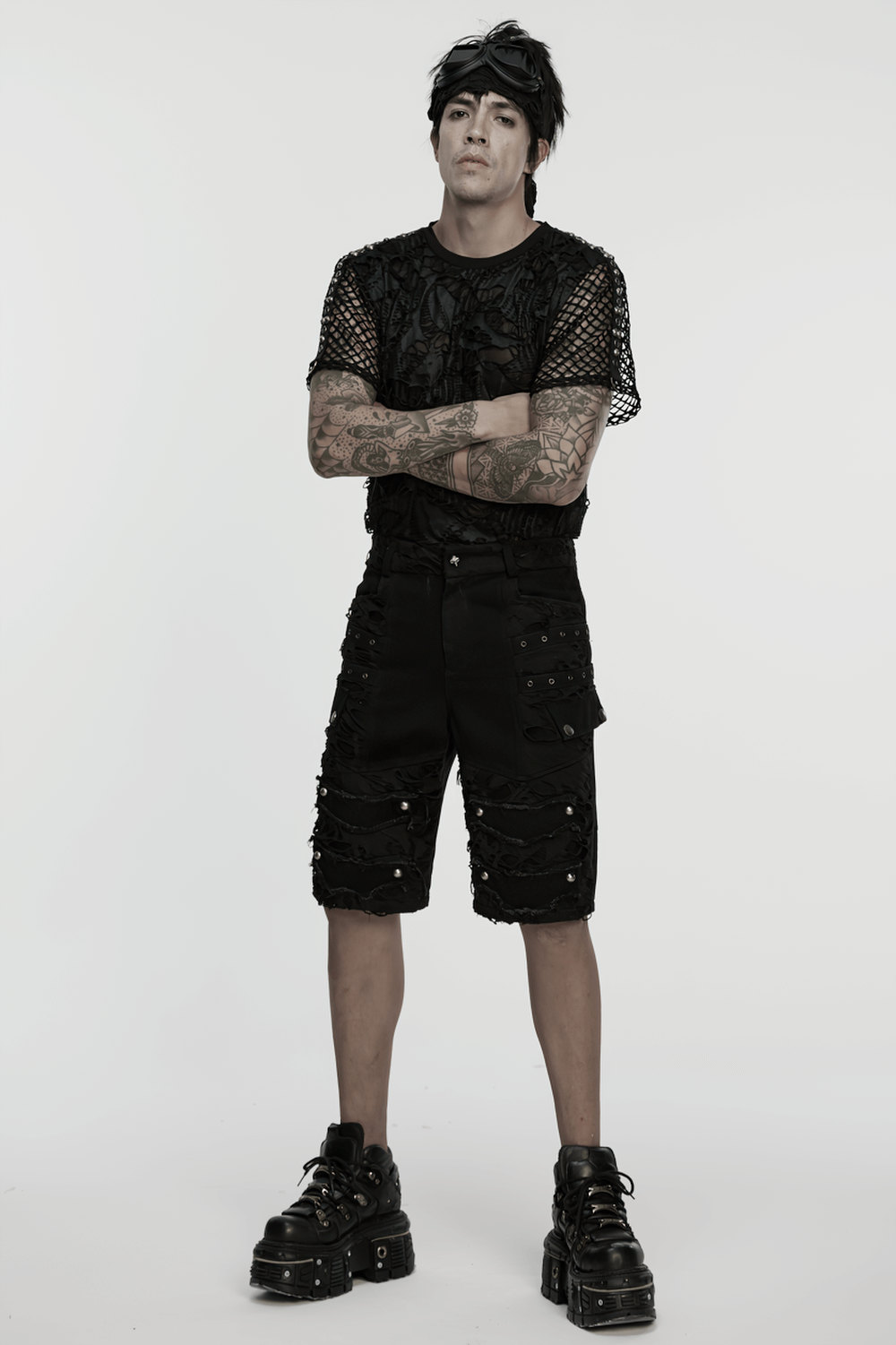 Model wearing black punk denim shorts with tattered detail and tassels, styled for an edgy fashion statement.