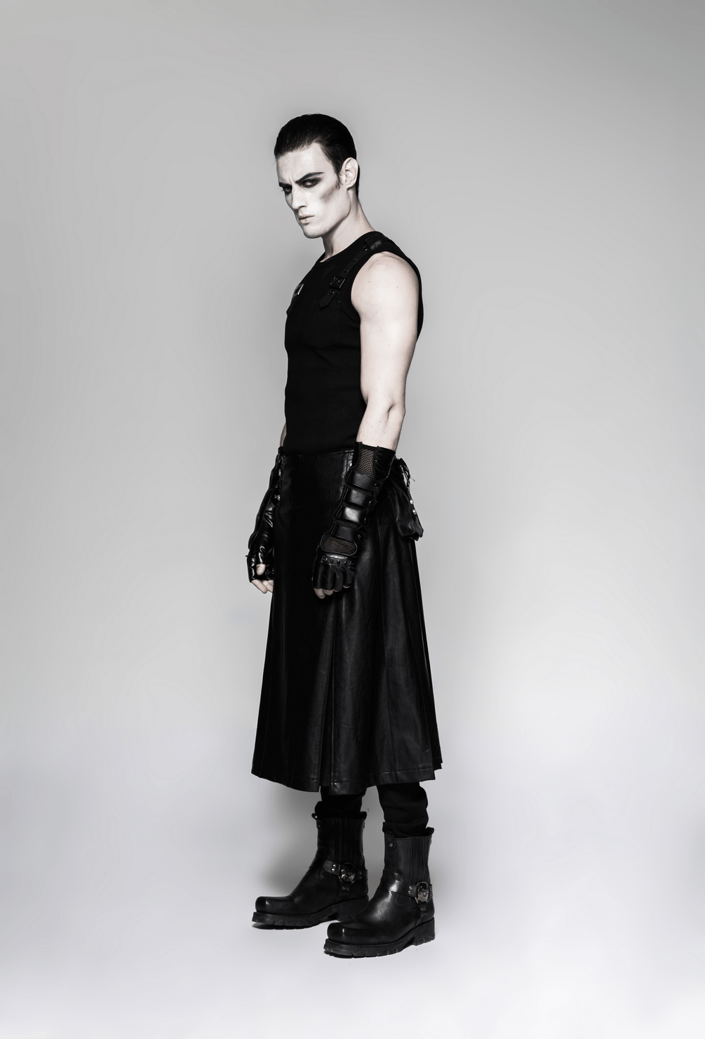 Model showcasing black punk gauntlet gloves with spiked joints and a sleek black outfit, embodying rebellious style.