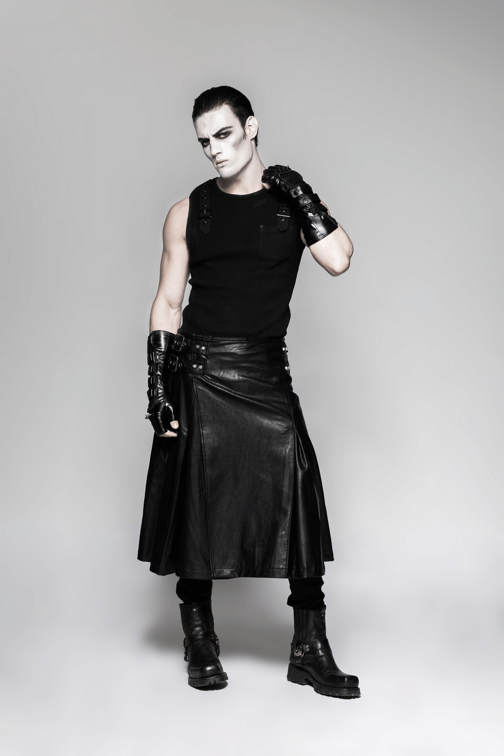 Model showcasing punk style in black tank and leather skirt with spiked gauntlet gloves and edgy boots.