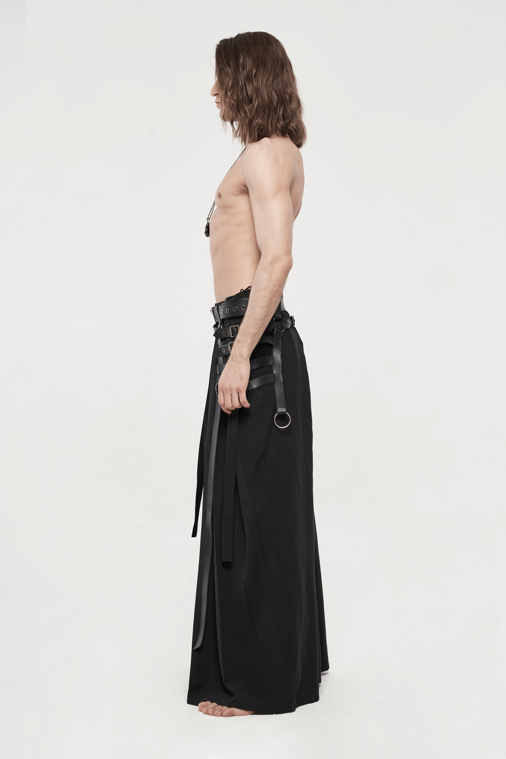 Side view of a model wearing black punk kimono wide leg hakama pants with adjustable buckles.