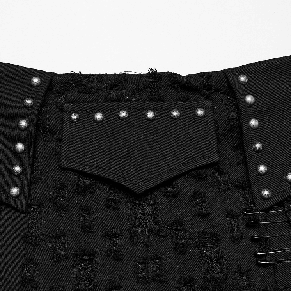 Close-up of black punk mini skirt showing studded details and side pocket flap with safety pins.