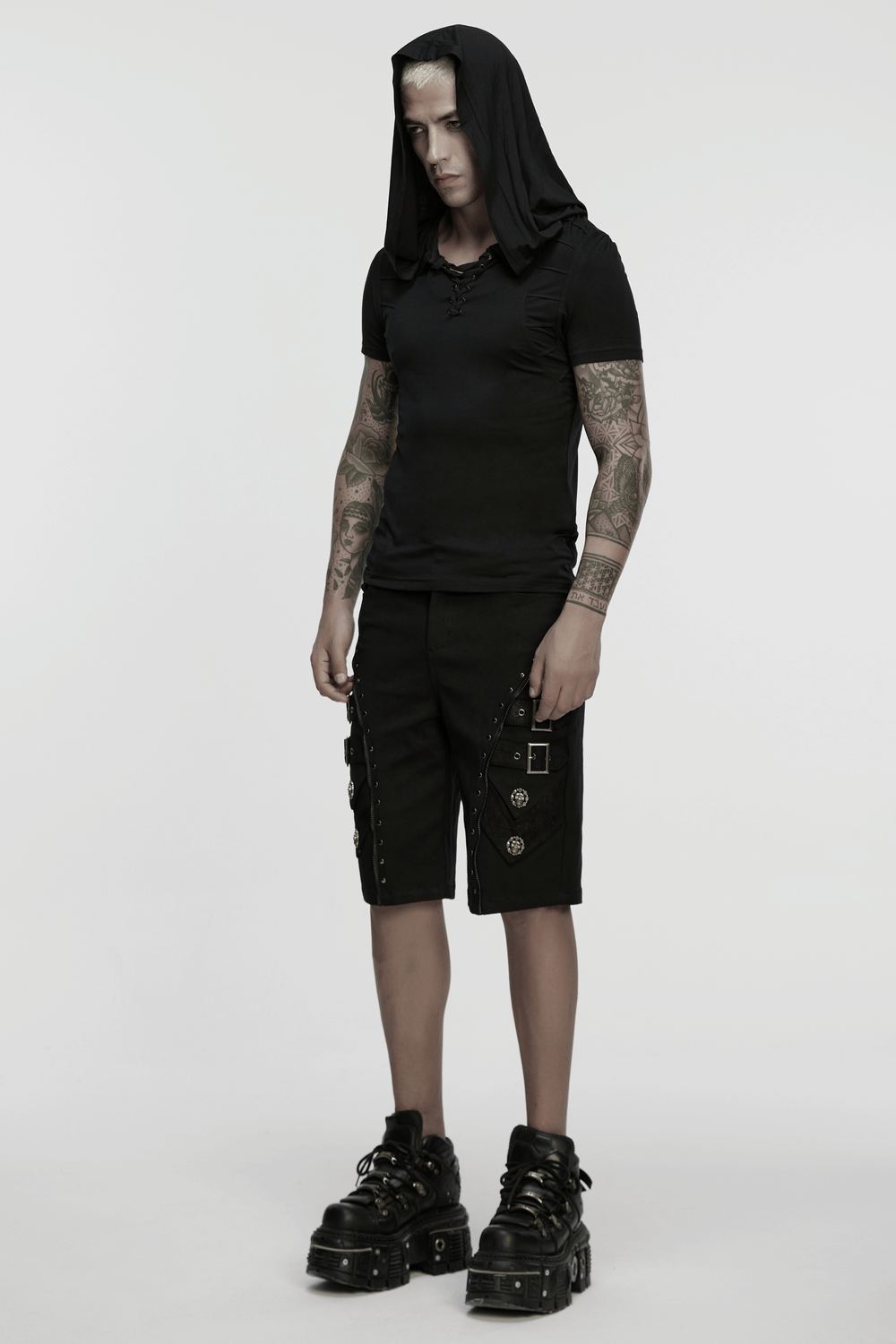 Model wearing black punk shorts with armor details, skull rivets, and oversized platform shoes.