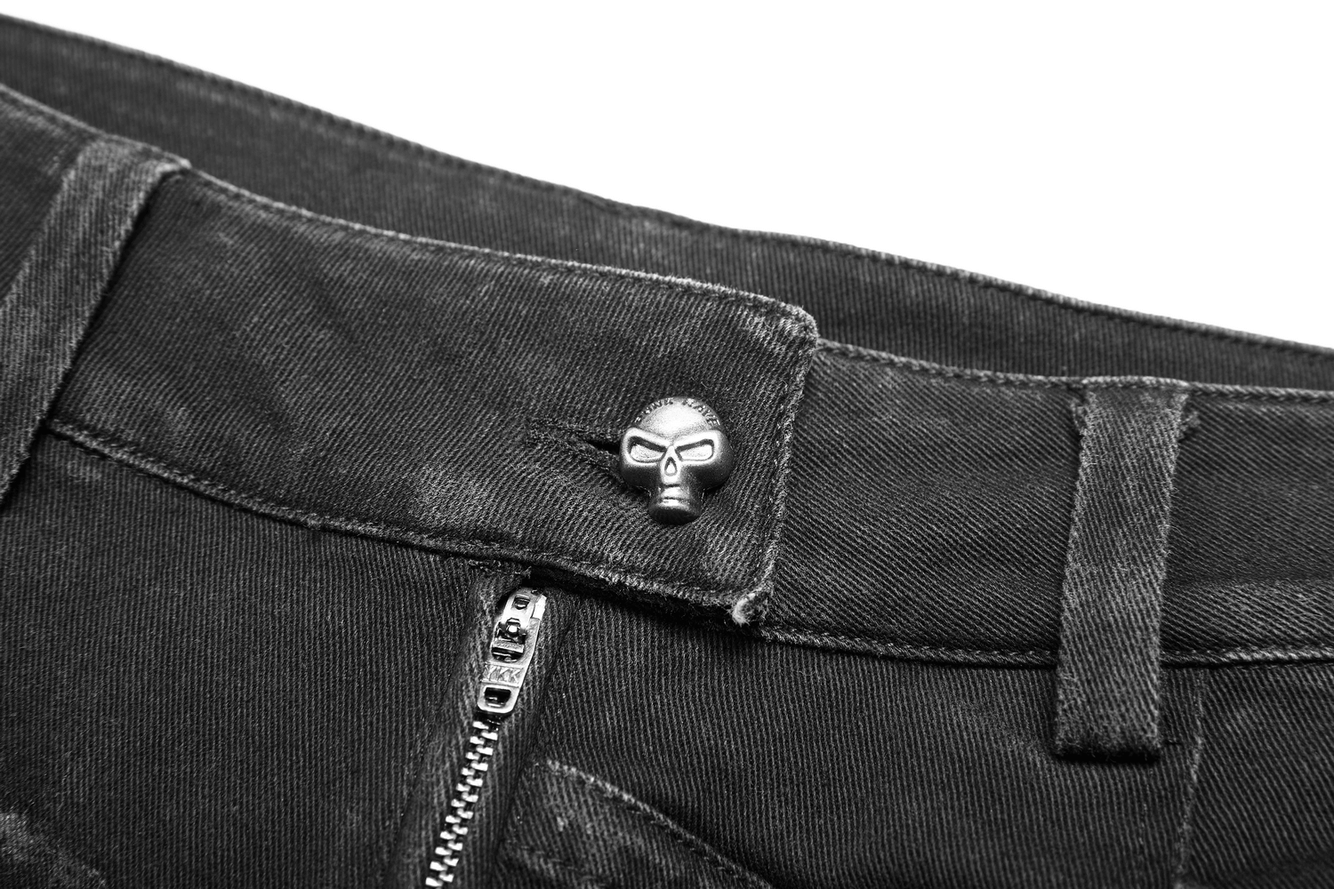 Close-up of a punk-style black jeans waistband featuring a unique skull button detail.