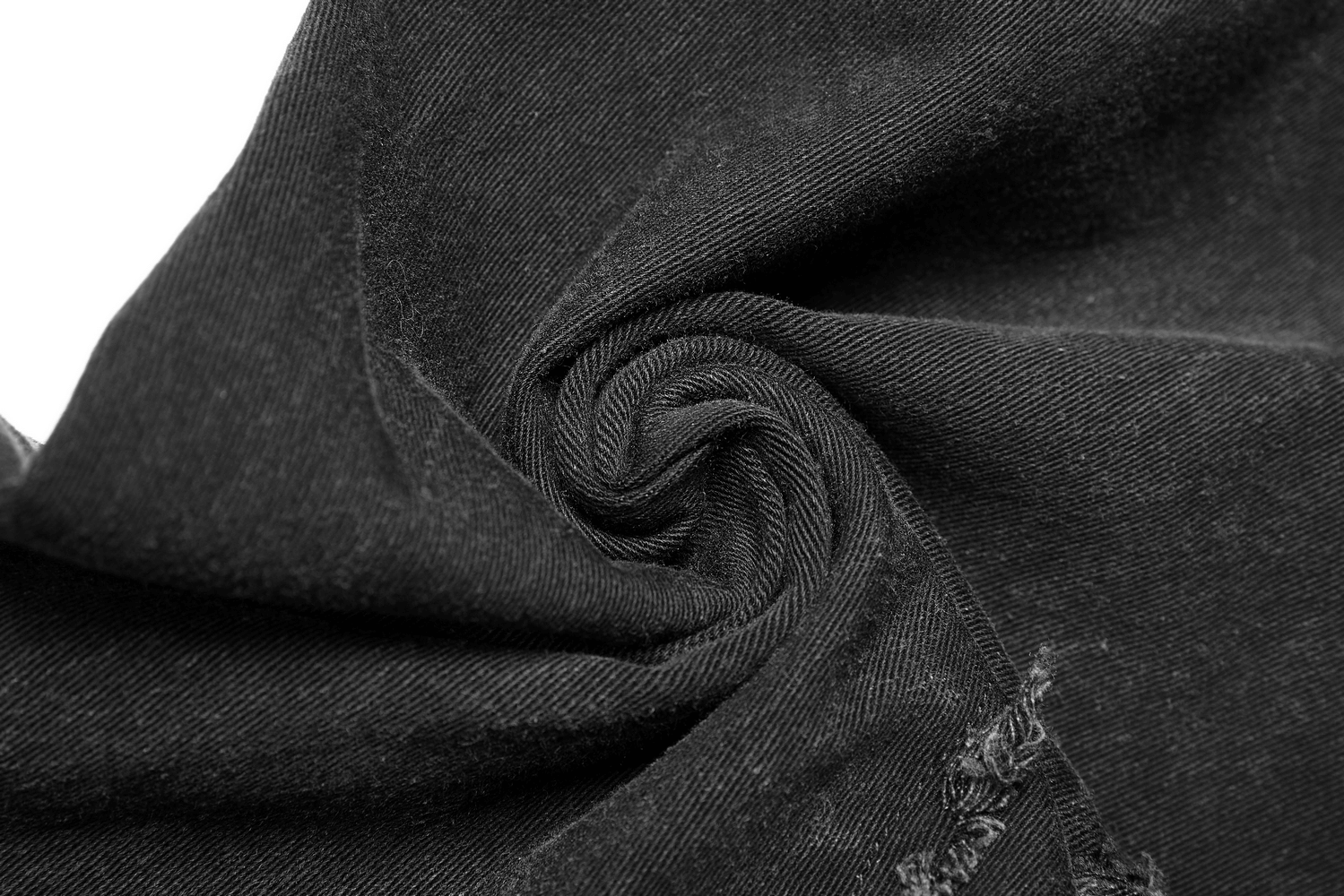 Close-up of black denim showcasing the texture and rolled fabric of punk-style ripped jeans.