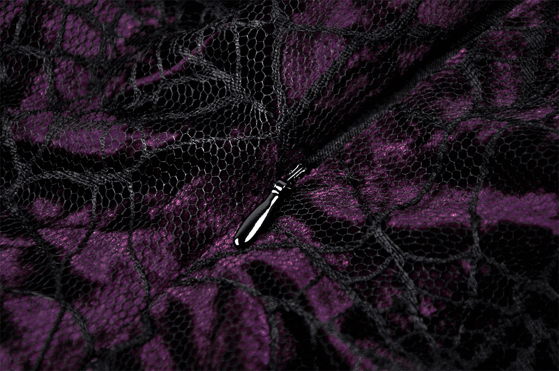 Close-up of black velvet and purple lace fabric, showcasing intricate gothic design details.