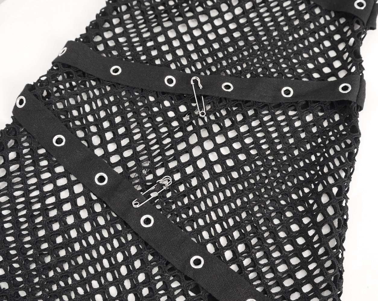 Close-up of black mesh fabric with grommet detailing and safety pins, perfect for edgy fashion looks.