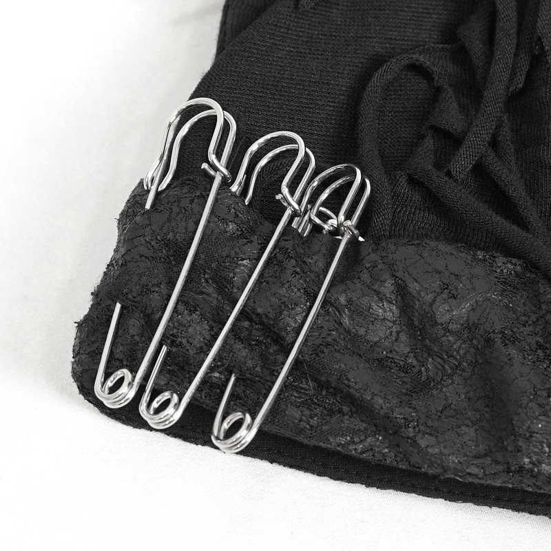 Close-up of metal safety pins on a black fabric, enhancing punk and gothic fashion styles.
