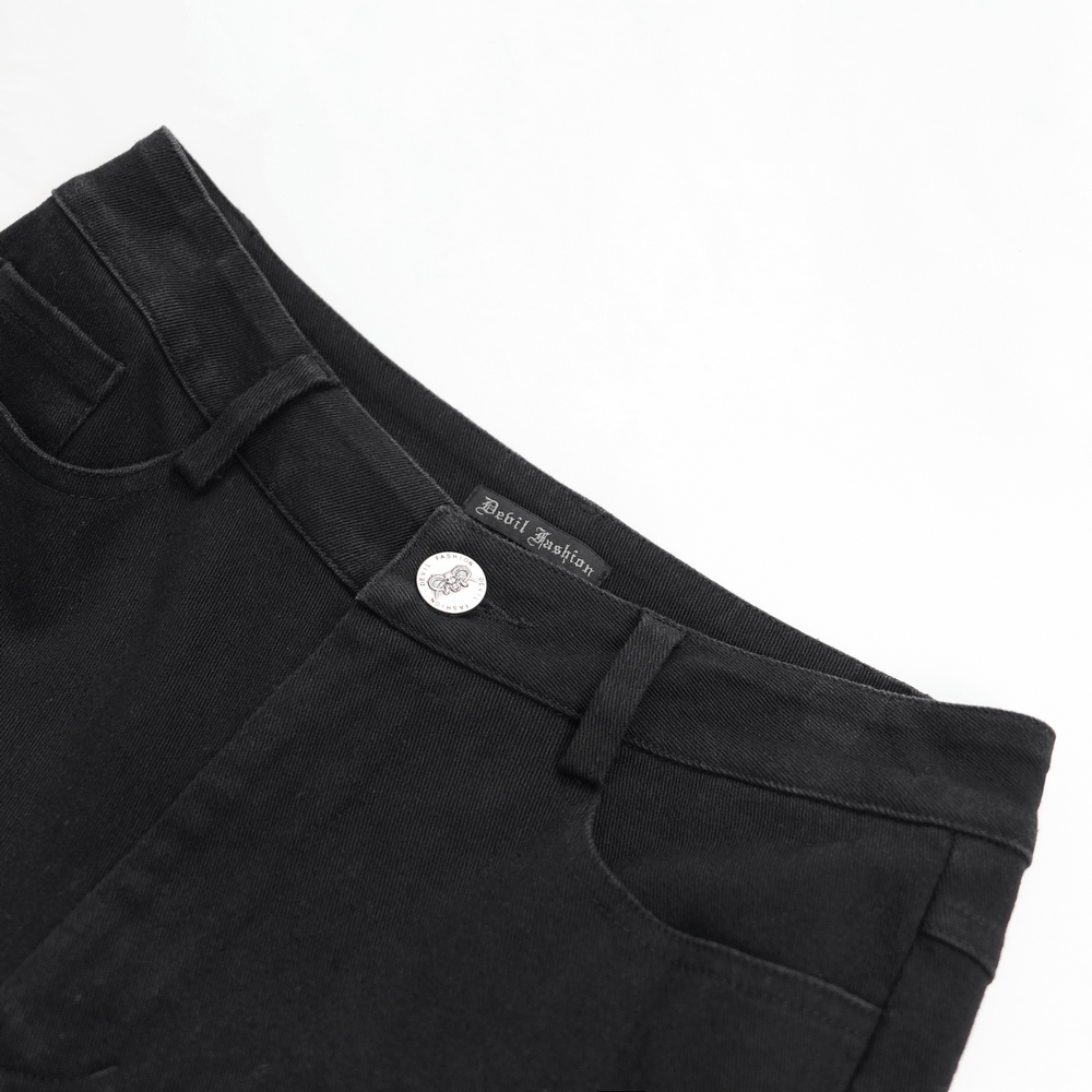 Close-up of black ripped skinny jeans with a silver button and "Devil Fashion" label, showcasing edgy gothic style.