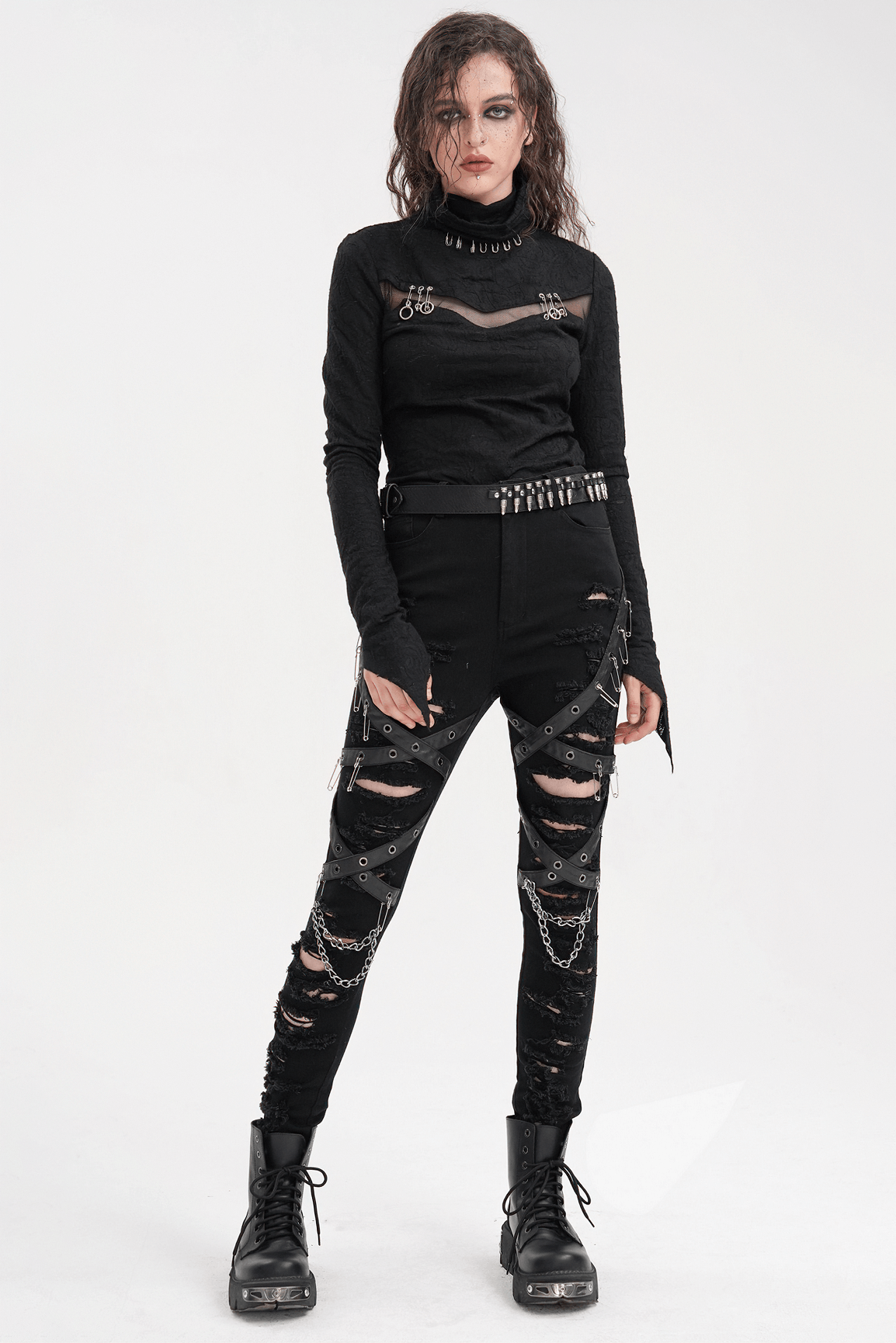 Edgy model in black ripped skinny jeans with chains and buckles, showcasing a bold gothic style with metal details.