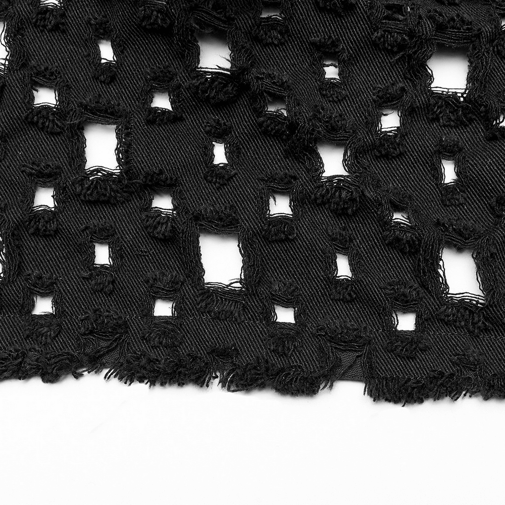 Close-up of black ripped twill fabric with hollow-out design, showcasing edgy texture and unique pattern.