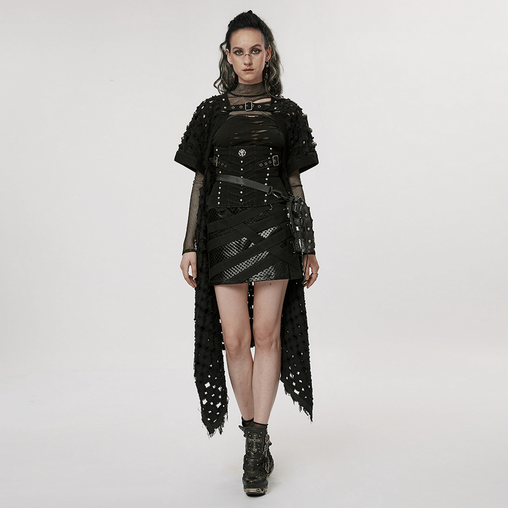 Edgy model wearing a black ripped twill long cardigan-cape with skull rivets and asymmetrical hem.
