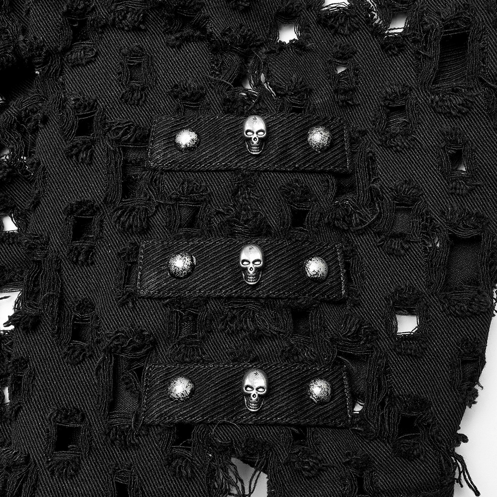 Close-up of a black twill fabric featuring skull rivets and a dramatic hollow-out design for an edgy look.