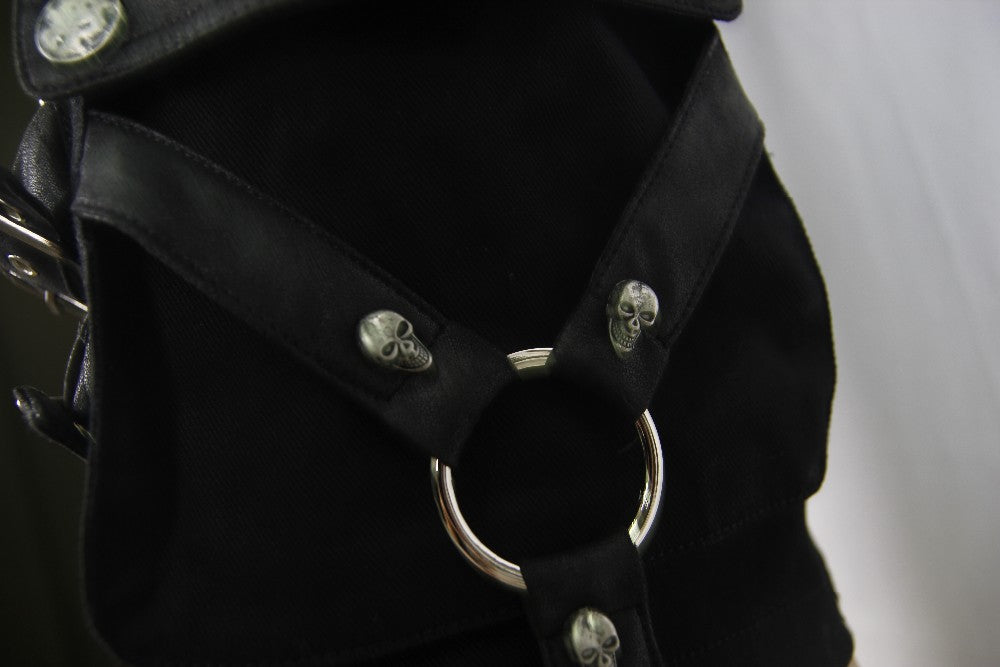 Close-up of black rock shorts featuring skull embellishments and a metal ring, perfect for gothic fashion.