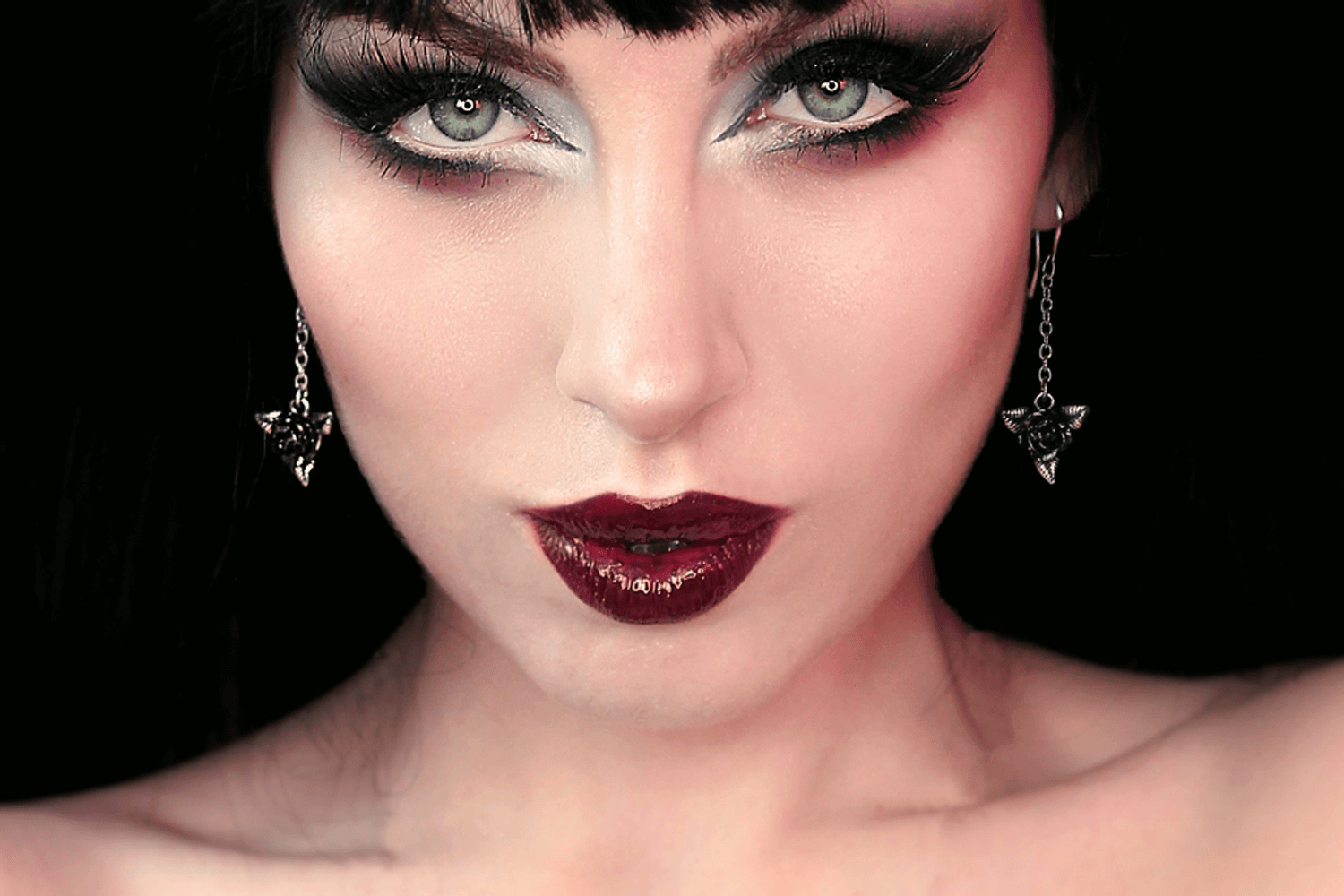 Mysterious woman with striking makeup wearing Black Rose Dropper Earrings, exuding gothic elegance and allure.