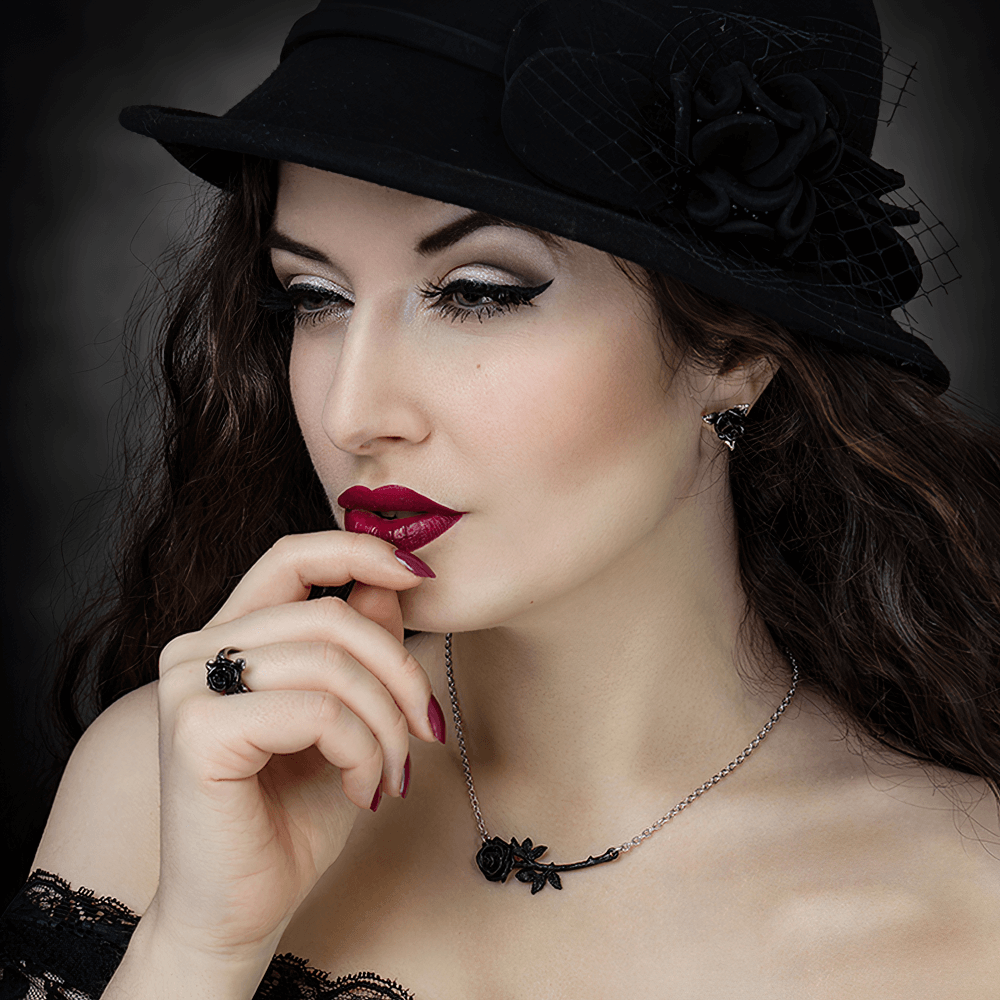 Elegant model wearing black rose triangular stud earrings and a matching necklace, showcasing gothic fashion style.
