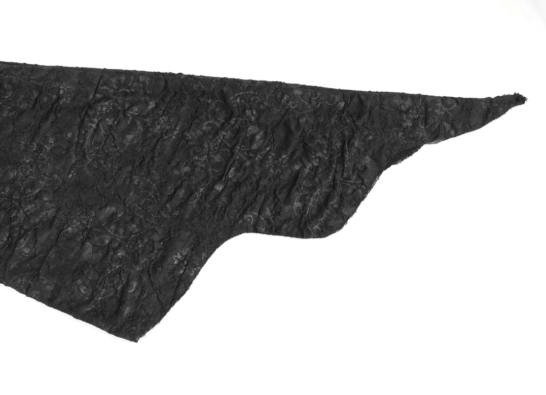 Close-up of intricate black lace fabric featuring a unique irregular cut for a gothic dress design.