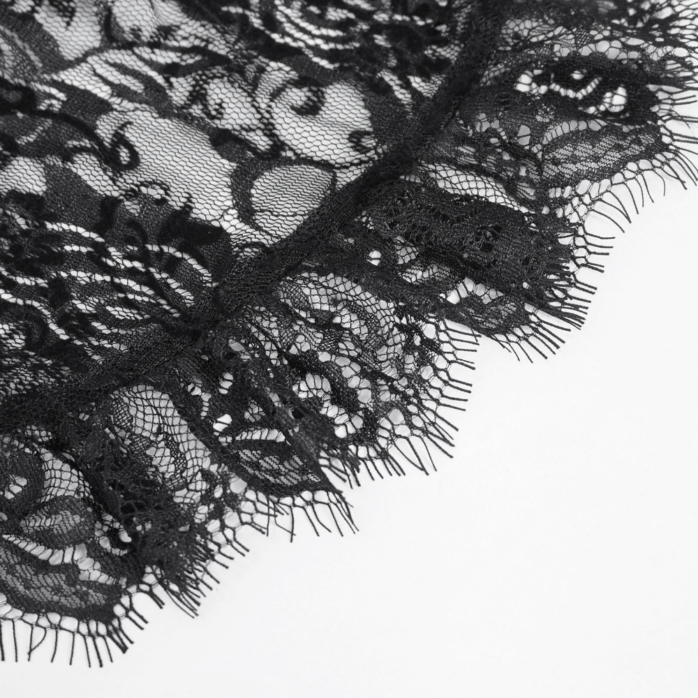 Close-up of black sheer lace with intricate floral patterns and a scalloped edge, highlighting gothic romance elegance.