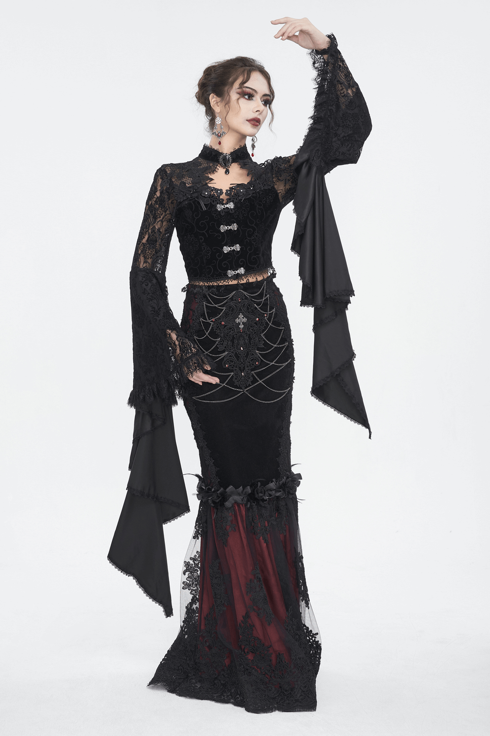 Elegant model in black sheer lace crop top with long bell sleeves and dramatic skirt, embodying gothic romance style.