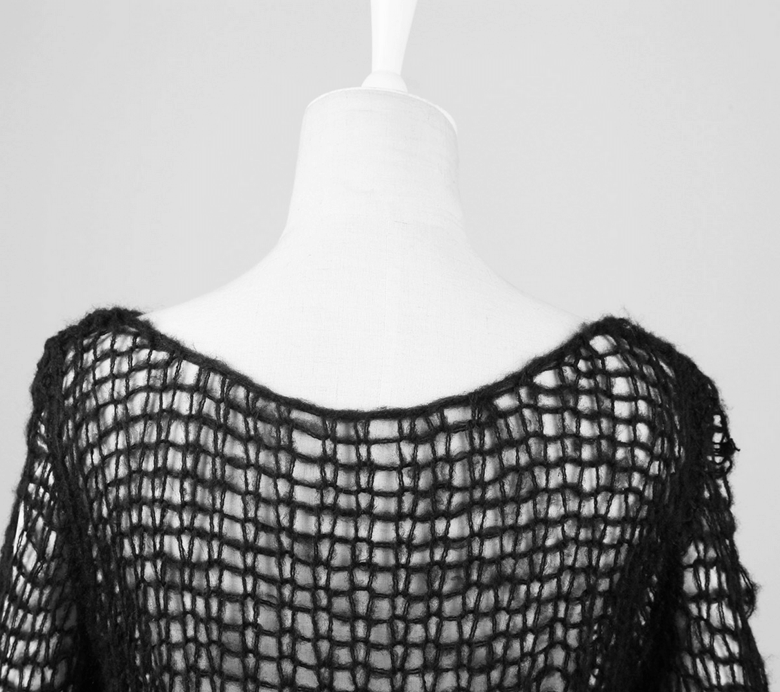 Back view of a black shredded knit crocheted sweater with loose-knit design and wide neckline.