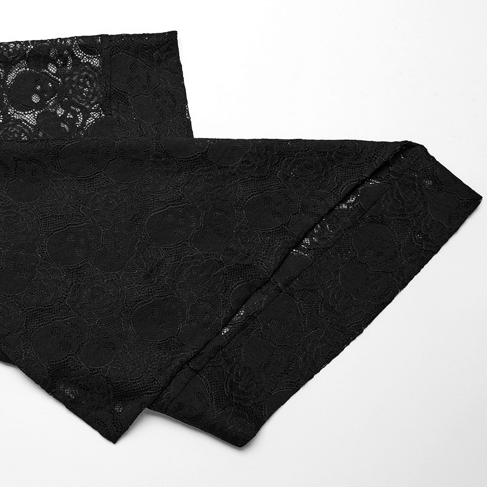 Close-up of black lace fabric featuring skull and rose patterns, perfect for gothic fashion designs.