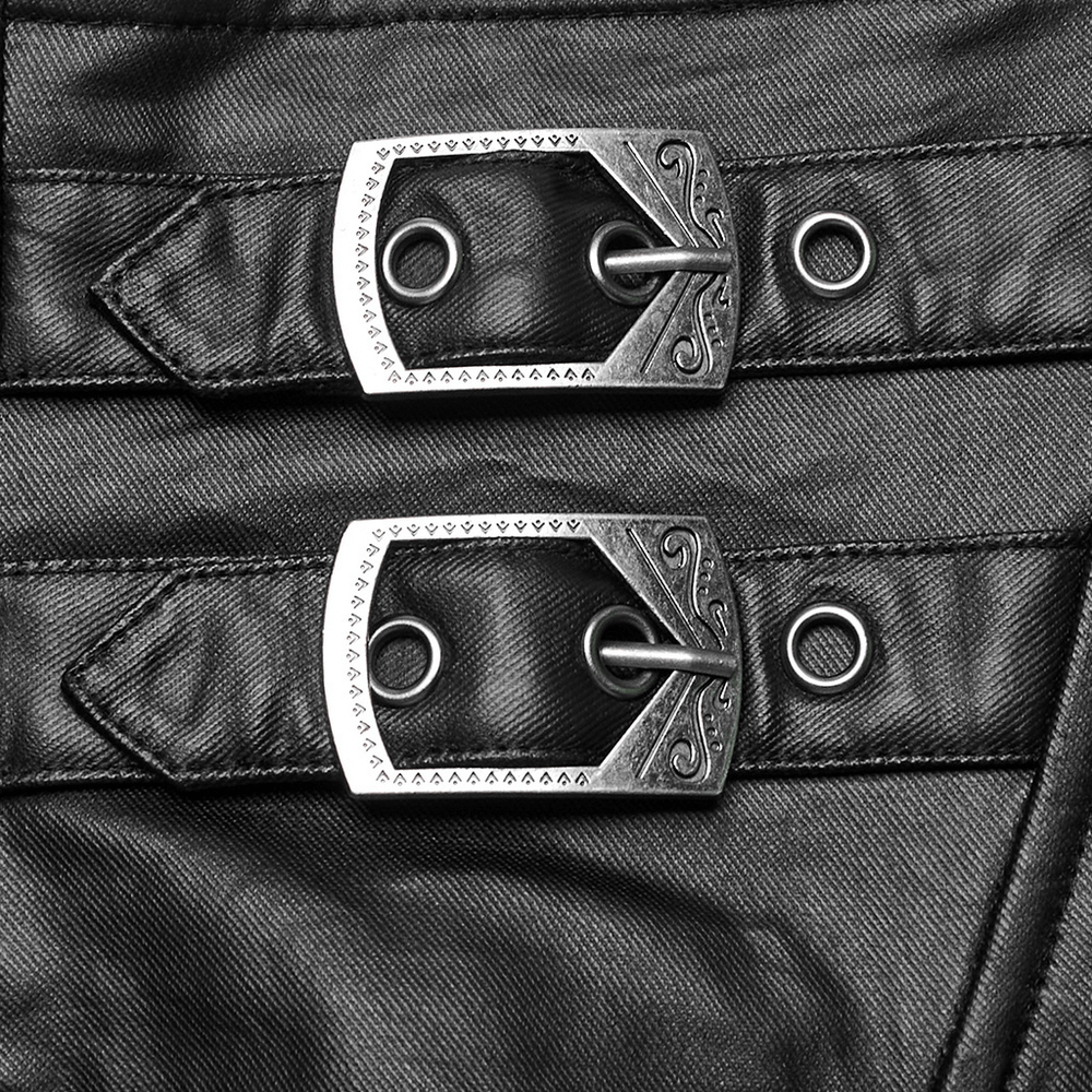 Close-up of decorative silver buckles on a black fabric featuring edgy design elements.