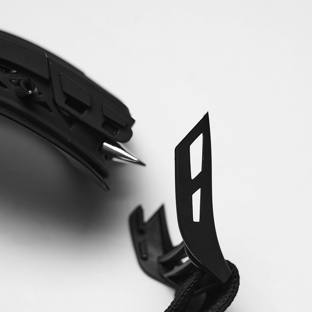 Close-up of black spiked punk goggles showing adjustable strap and sharp spikes for a cyberpunk look.