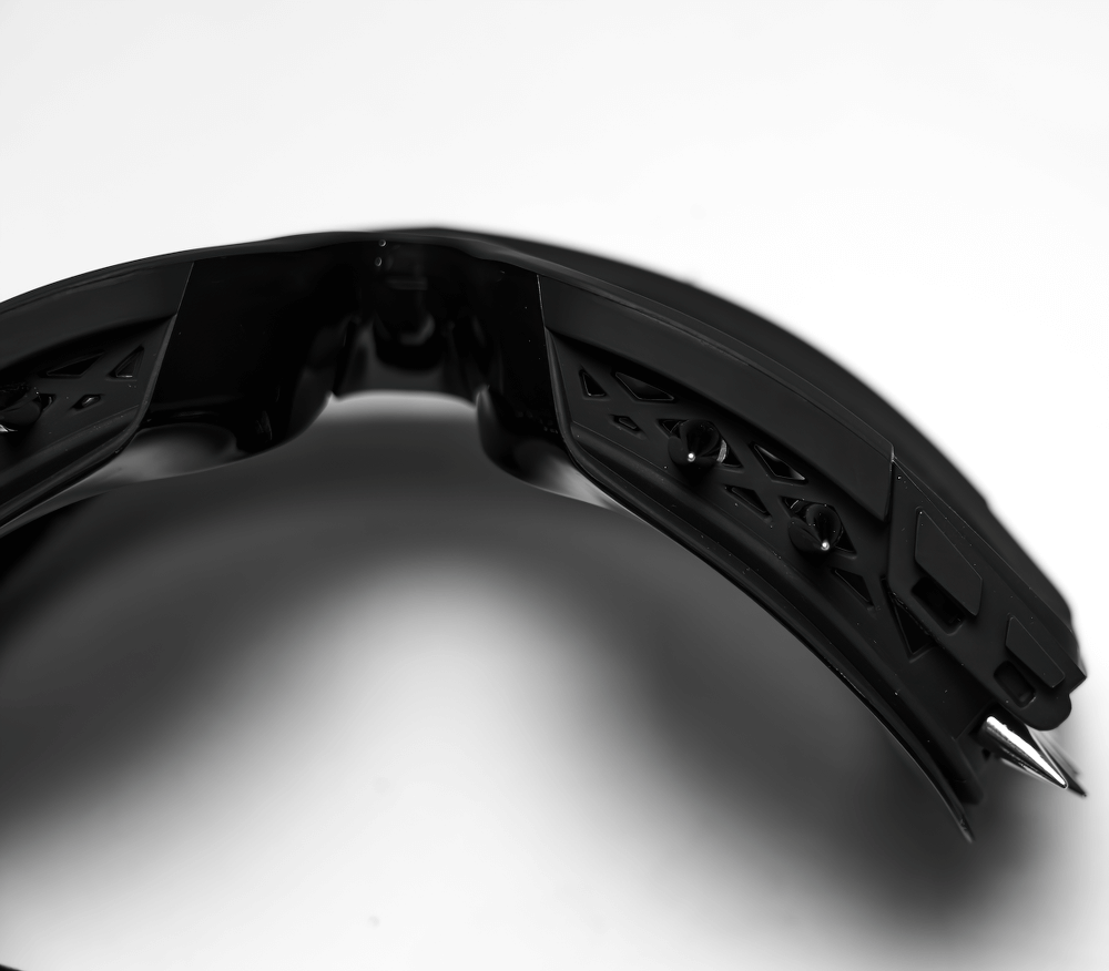 Close-up of black spiked punk goggles featuring adjustable elastic strap and intricate design.