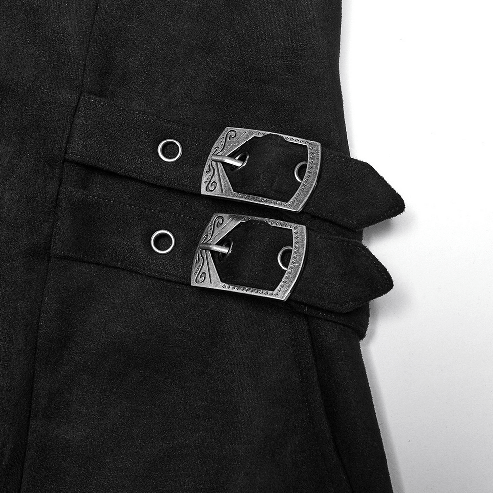 Close-up of decorative hand-sewn buckles on a black suede gothic cape coat with adjustable waist loops.