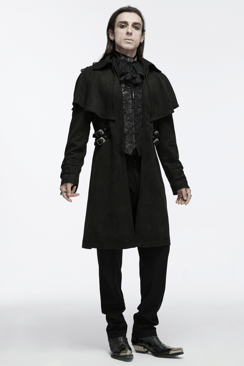 Model showcasing a black suede gothic cape coat with decorative buckles and adjustable waist loops against a plain background.