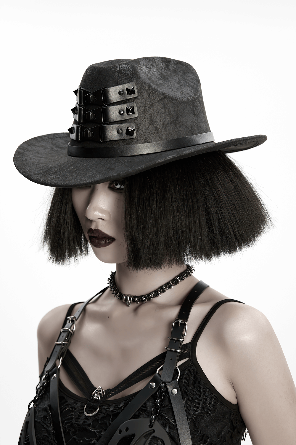 Black suede steampunk hat with triple buckle straps worn by model, showcasing punk and gothic style.