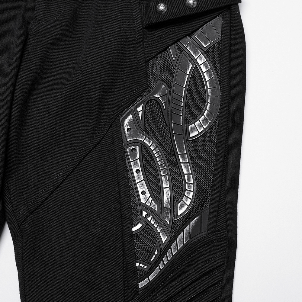 Close-up of black techwear trousers featuring intricate rubber patch details for a modern look.