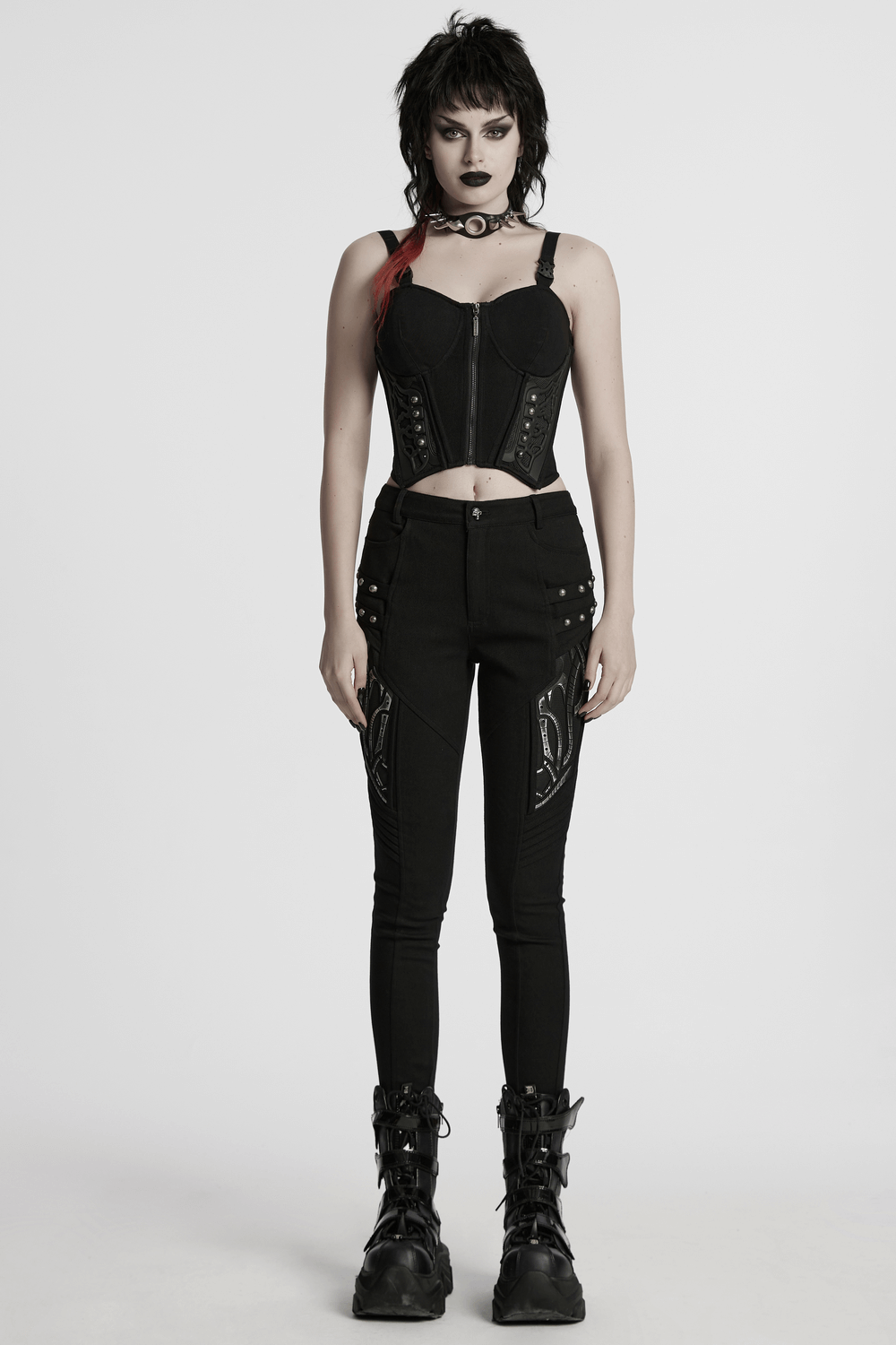 Black techwear trousers with rubber patch details, paired with a stylish black corset and edgy accessories.