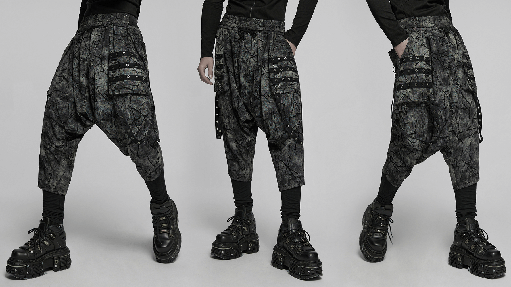 Black tie-dye drop crotch pants featuring eyelet straps, stylish and edgy look for fashion-forward individuals.