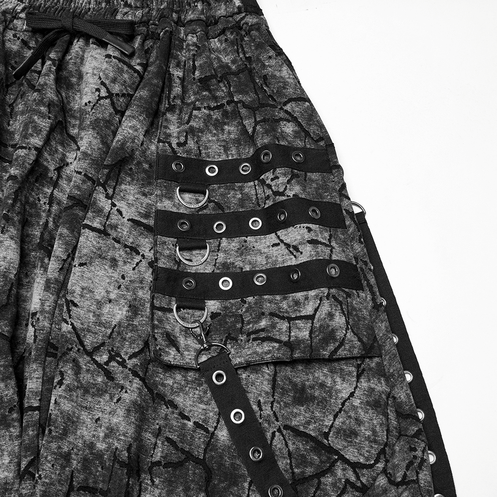 Close-up of black tie dye drop crotch pants featuring stylish eyelet straps and a unique textured design.