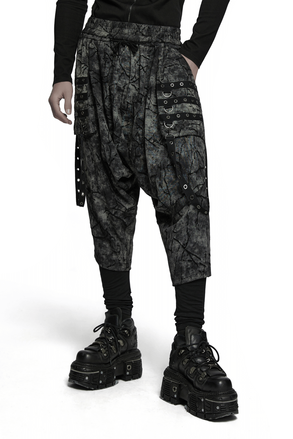 Black tie dye drop crotch pants with eyelet straps, perfect for a bold streetwear look.