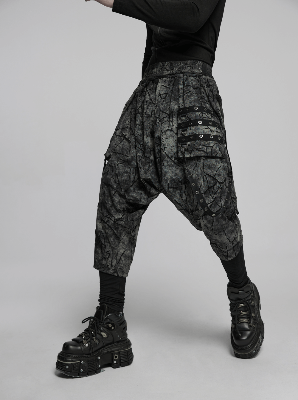 Black tie dye drop crotch pants featuring eyelet straps, perfect for a trendy streetwear look.