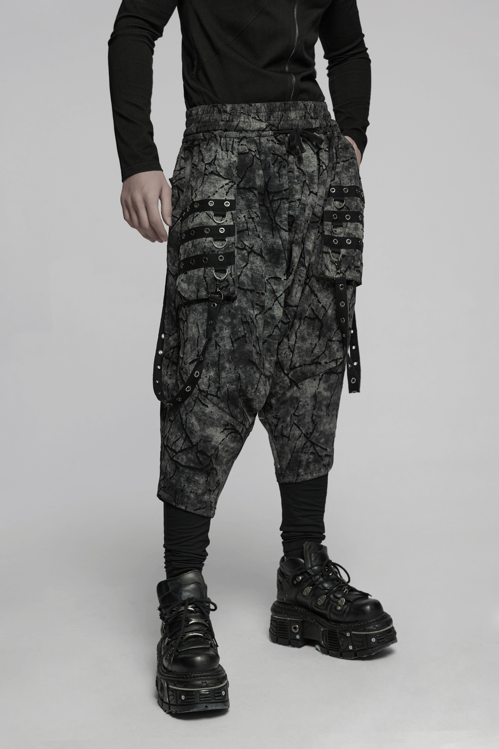 Black tie dye drop crotch pants with eyelet straps, styled with black chunky boots.