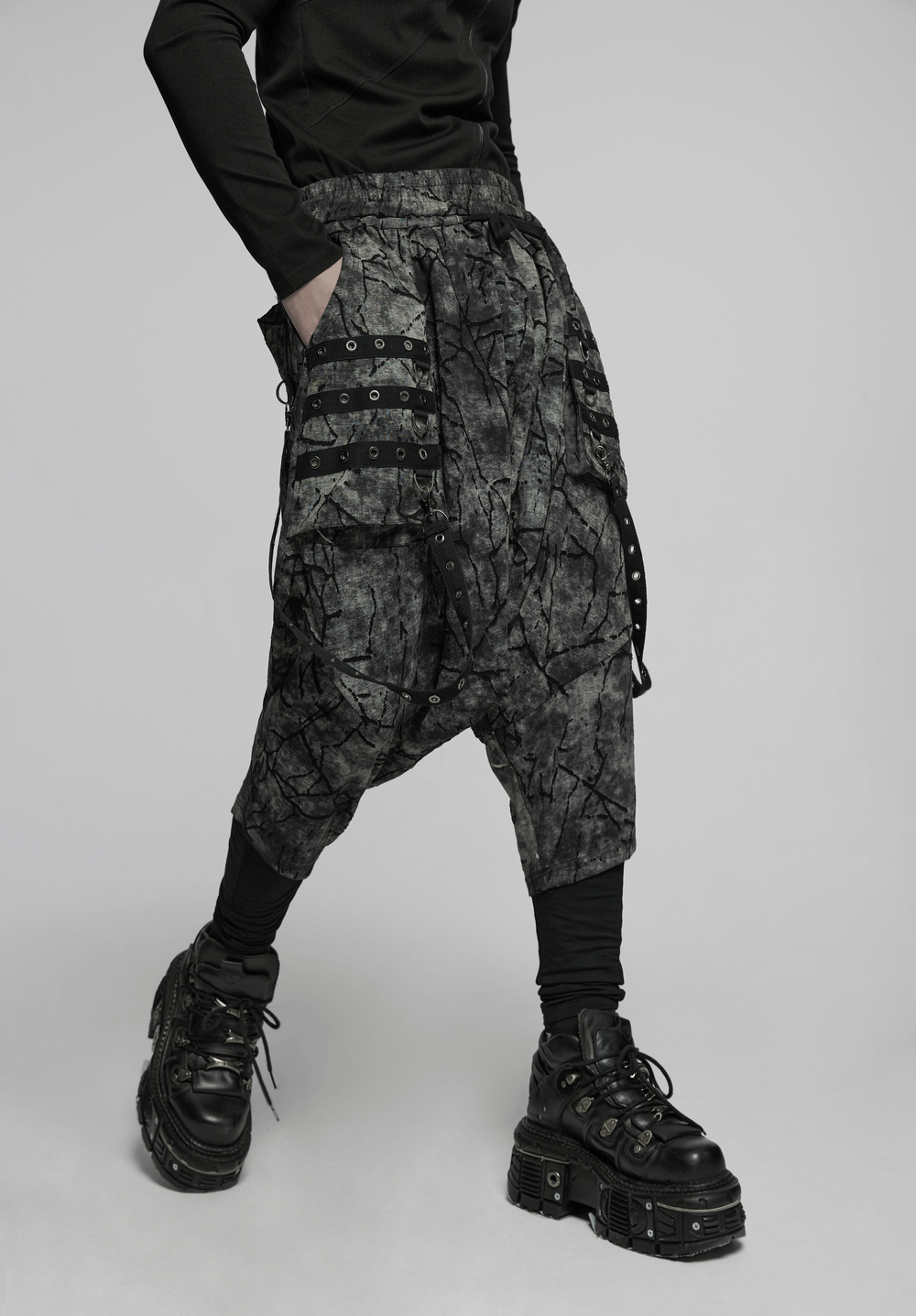 Black tie dye drop crotch pants with eyelet straps, perfect for edgy street style fashion.