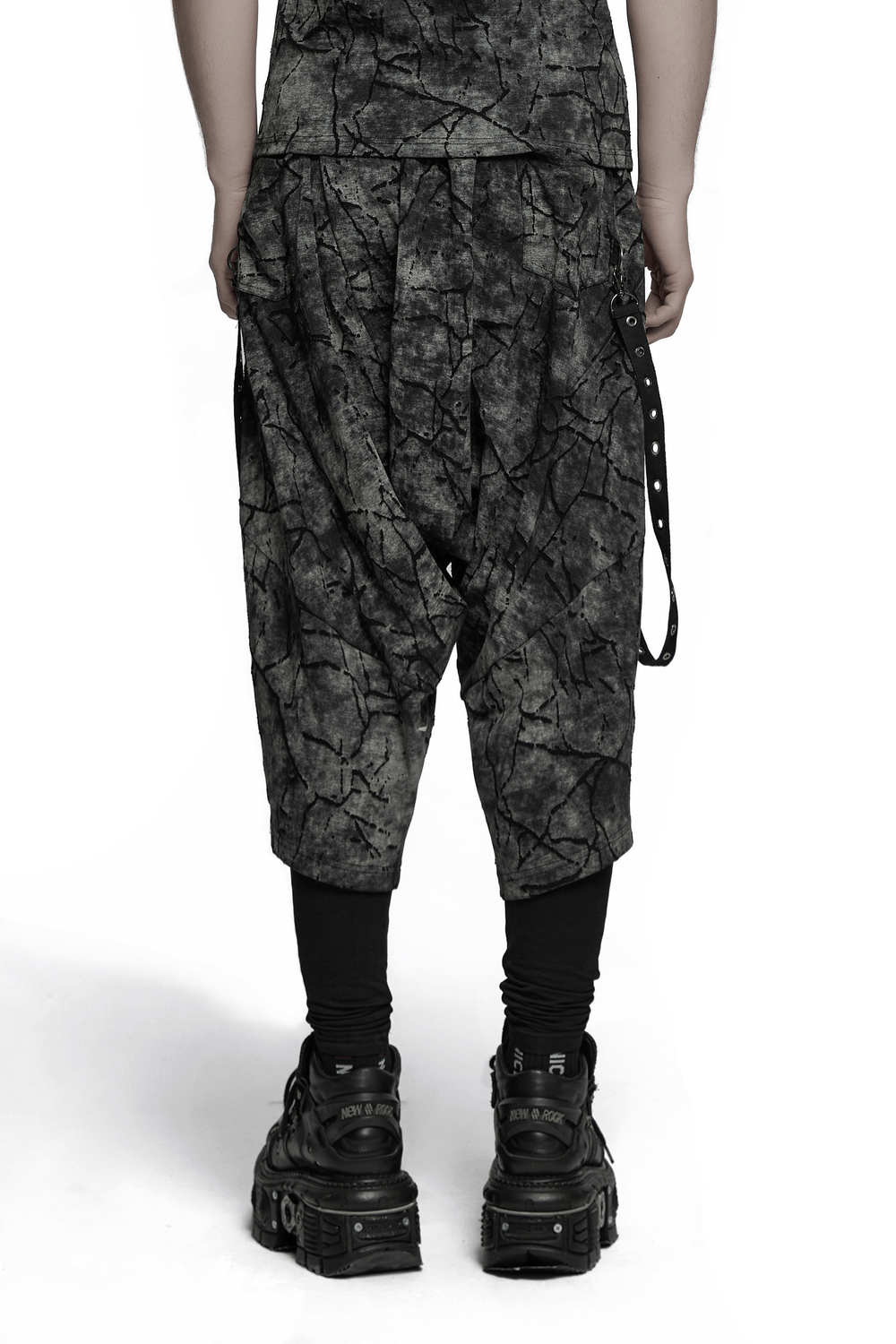 Black tie dye drop crotch pants with eyelet straps, stylish and trendy, perfect for a bold streetwear look.