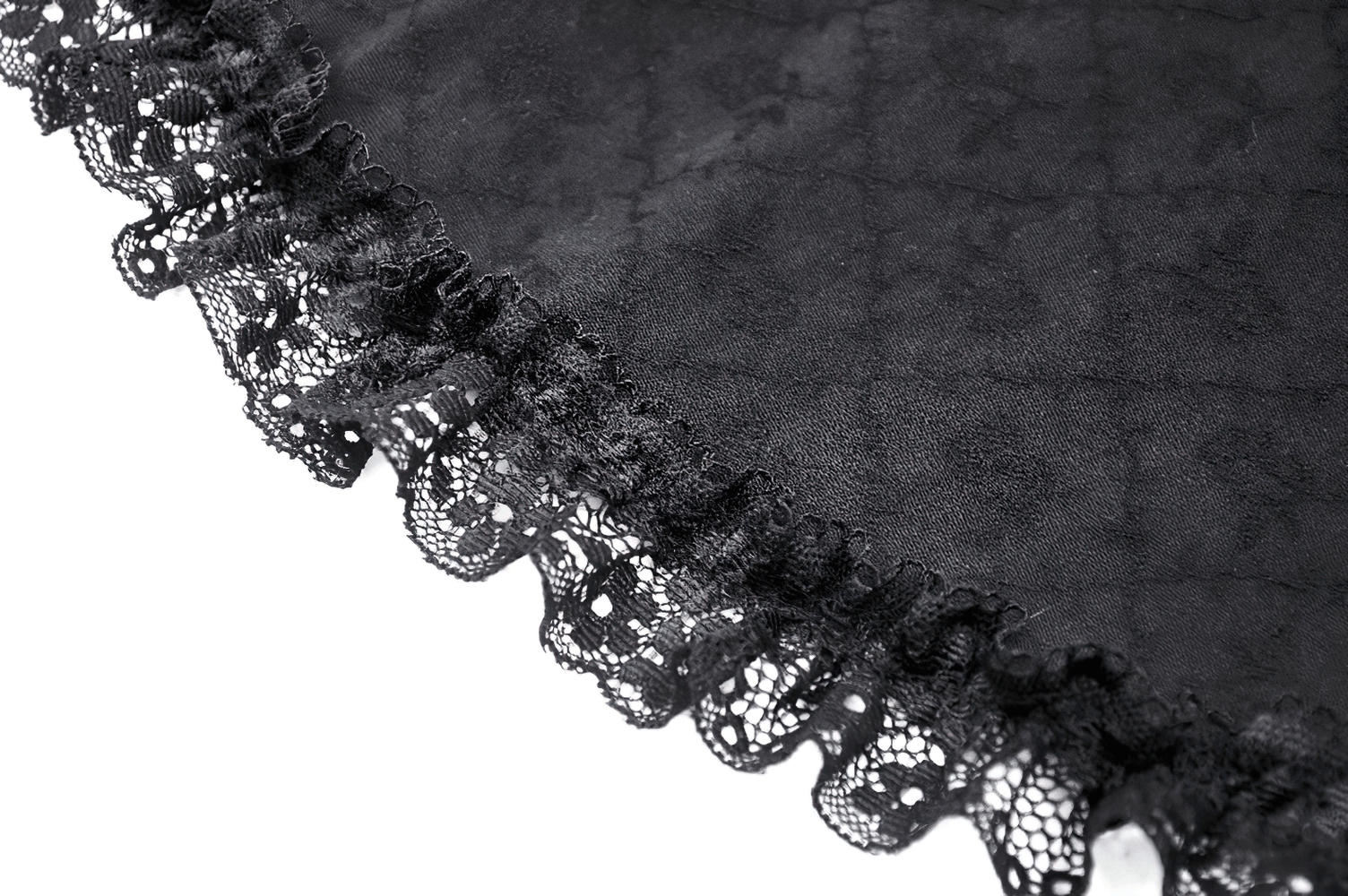 Close-up of black tiered ruffle detailing on a mini skirt, showcasing elegant lace trim and soft fabric texture.