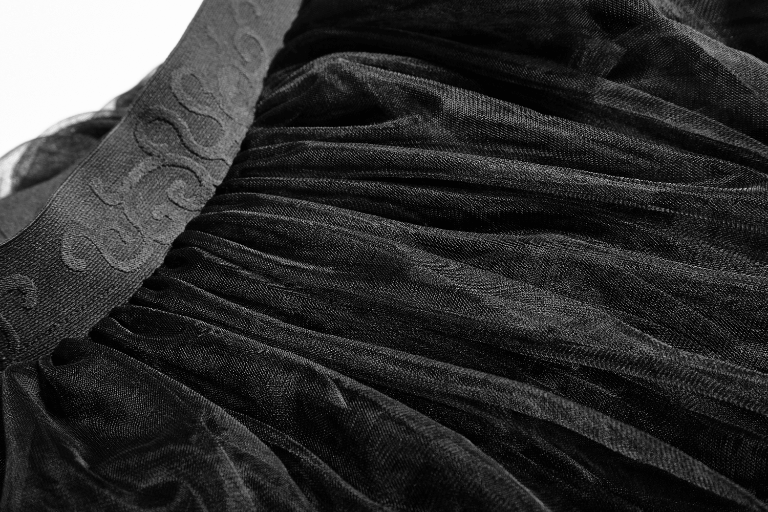 Close-up of black tulle fabric with lace details, showcasing the elegant design of a gothic wedding dress crinoline.