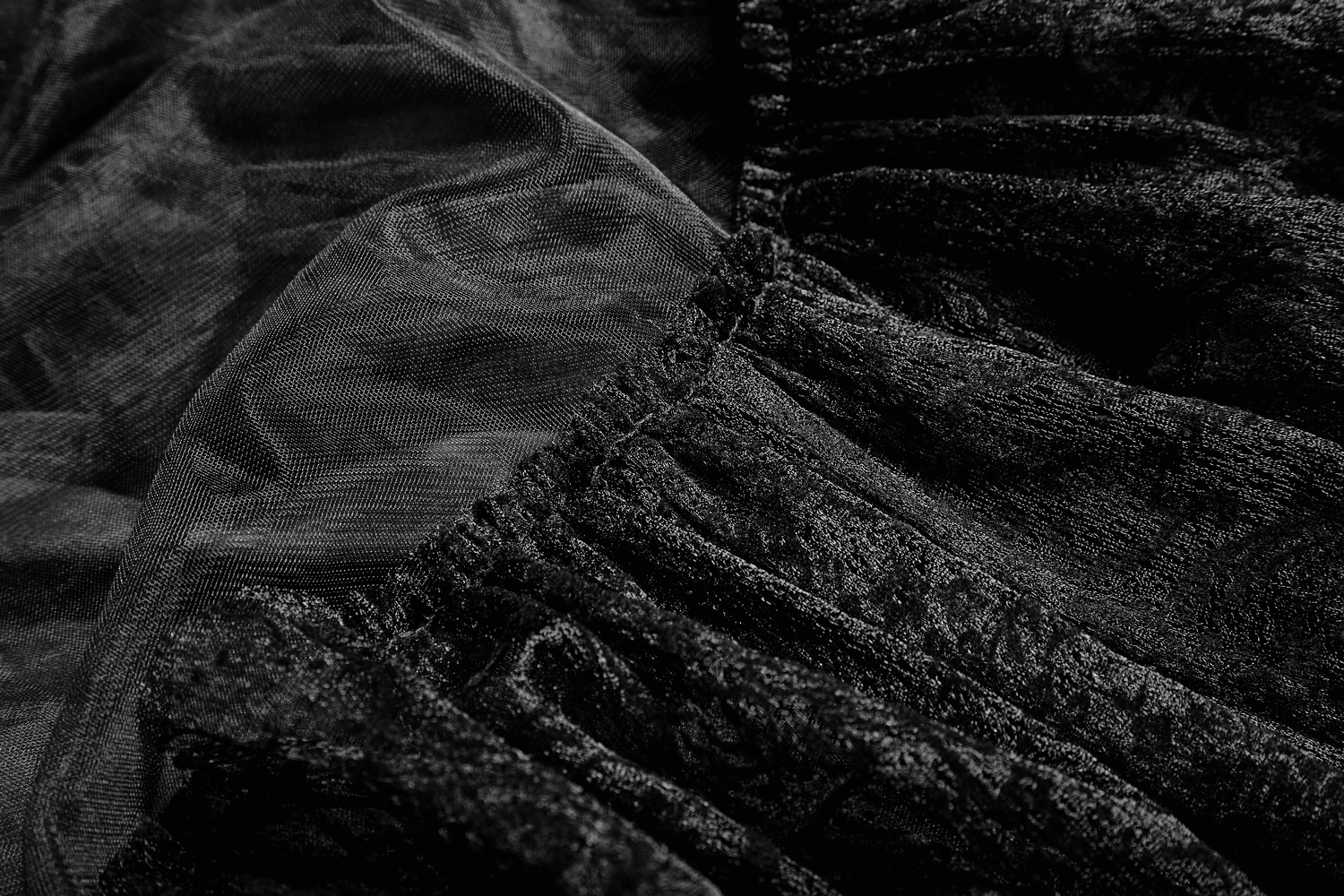 Close-up of black tulle fabric and lace trim, showcasing texture for gothic wedding crinoline skirt.