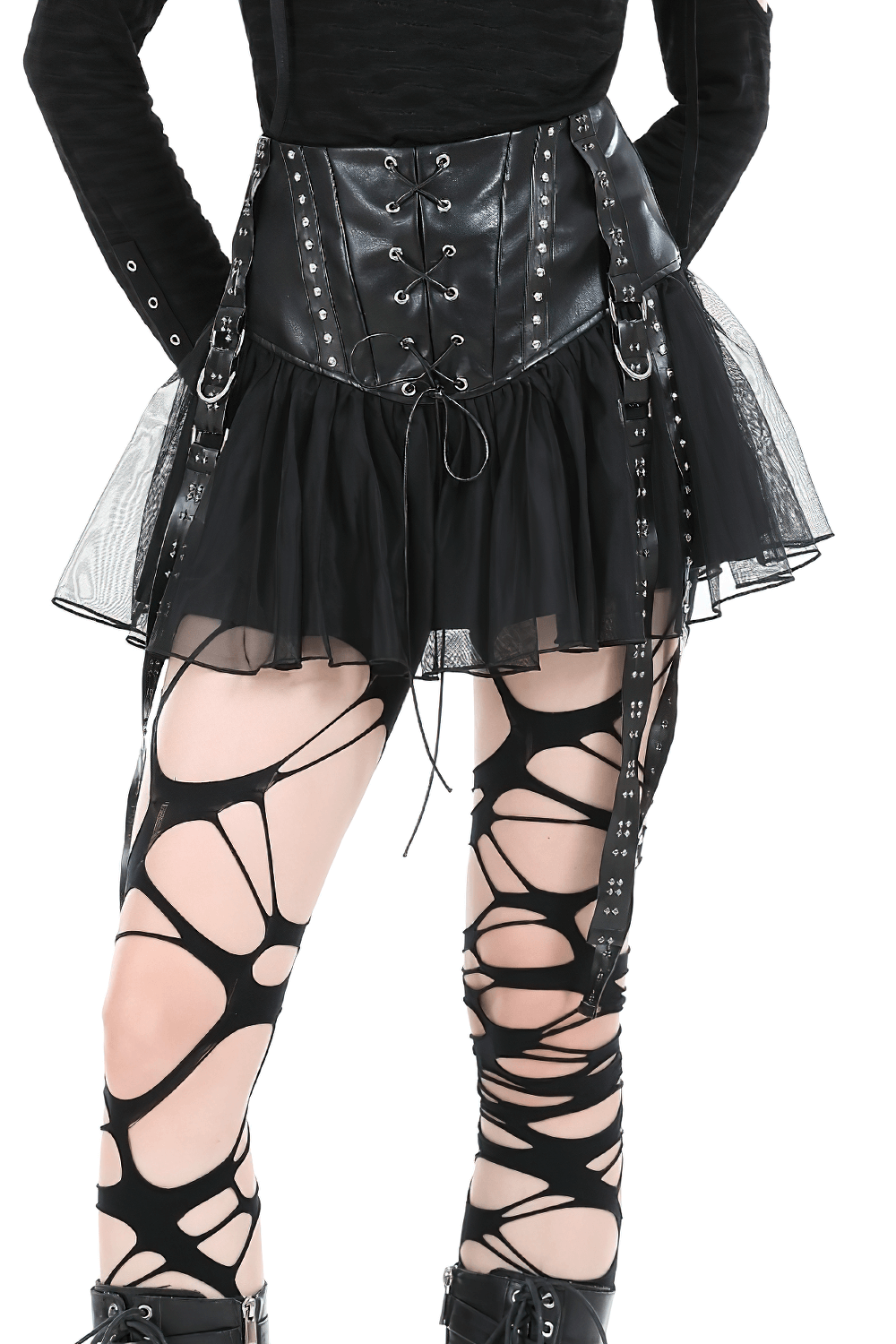 Back view of a black tulle mini skirt with corset lacing and studs, paired with edgy cut-out leggings.