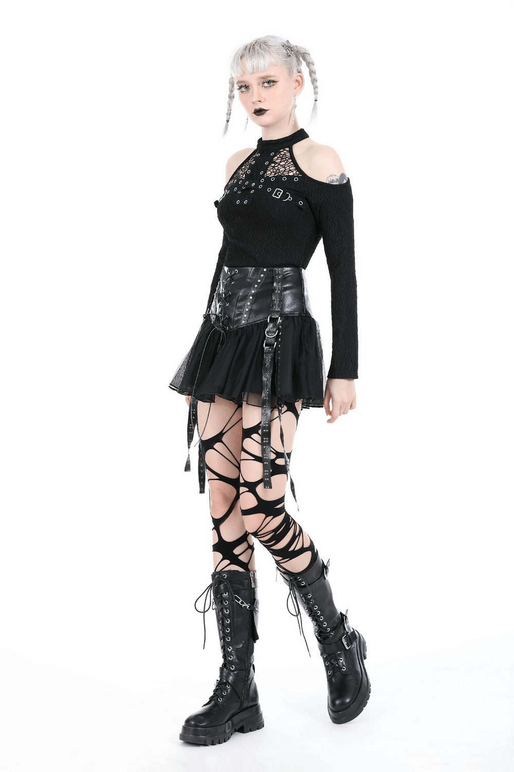Model wearing a black tulle mini skirt with lace-up front, paired with edgy accessories and combat boots.